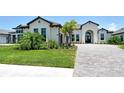 Well-manicured lawn and landscaping accentuates the exterior of this elegant single Gathering home at 10612 Nicklaus Ct, Englewood, FL 34223