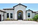 Beautiful arched entryway and manicured landscaping is captured in this exterior front door real estate listing shot at 10612 Nicklaus Ct, Englewood, FL 34223