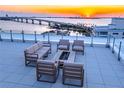 Relaxing rooftop deck with outdoor furniture and incredible sunset views at 111 Golden Gate Pt # 401, Sarasota, FL 34236