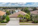 An elevated view showcases the home's well-maintained landscaping, three-car garage, and access to a beautiful lake at 16621 Berwick Ter, Lakewood Ranch, FL 34202