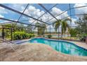 Relax by the screened-in pool overlooking the serene lake, complete with lounge chairs and lush greenery at 16621 Berwick Ter, Lakewood Ranch, FL 34202