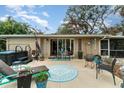 Relaxing backyard patio with comfortable seating, an outdoor dining area, and a hot tub at 2885 Arrowhead Rd, Venice, FL 34293