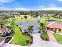 Beautiful aerial view of a landscaped home near a golf course, ponds, and other neighborhood houses at 6170 Misty Oaks Dr, Sarasota, FL 34243