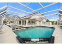 An in-ground pool surrounded by a screened enclosure, with tables and lounge chairs providing an outdoor living space at 6170 Misty Oaks Dr, Sarasota, FL 34243