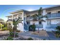 Exterior of a condo unit with a balcony, palm trees, and blue and gray accents at 6800 Placida Rd # 2017, Englewood, FL 34224