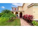 Inviting facade of a two-story home, showcasing red shutters and decorative front yard plants at 7315 Bianco Duck Ct, Sarasota, FL 34240