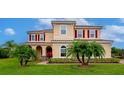 Beautiful two-story home with manicured lawn and decorative palm trees in a well landscaped front yard at 7315 Bianco Duck Ct, Sarasota, FL 34240