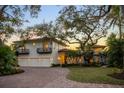 Stately home with a red-tiled roof, a three-car garage, and manicured landscaping at 3930 Red Rock Way, Sarasota, FL 34231