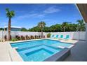 Relaxing backyard with a gorgeous pool, hot tub, lounge chairs, and lush tropical landscaping at 630 Companion Way, Longboat Key, FL 34228