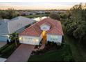 Aerial view of home with tile roof, landscaped yard, and scenic pond views at 11816 Altamonte Ct, Venice, FL 34293