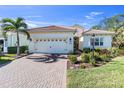 Beautiful home with tile roof, palm tree, brick driveway, and well-maintained landscaping at 11816 Altamonte Ct, Venice, FL 34293