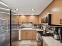 Well-lit kitchen featuring wood cabinets, stainless steel appliances, and a tile backsplash at 1655 58Th S Ter # 7, St Petersburg, FL 33712