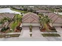 Charming home featuring a two-car garage, brick driveway, well-manicured landscaping and a classic tile roof at 20289 Benissimo Dr, Venice, FL 34293