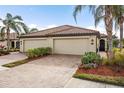 Home featuring a spacious two-car garage, a brick driveway, and well-maintained landscaping at 20289 Benissimo Dr, Venice, FL 34293