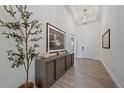 Bright foyer with stylish decor, wood-look flooring, high ceilings, and a modern chandelier at 328 Aria Dr, Nokomis, FL 34275
