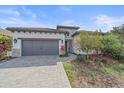 Beautiful single Gathering home featuring a paved driveway, gray garage doors, and colorful landscaping at 328 Aria Dr, Nokomis, FL 34275