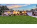 Charming single-story home with a well-manicured lawn and colorful landscaping, enhancing curb appeal at 2651 Leafy Ln, Sarasota, FL 34239