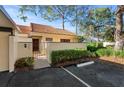 Well-maintained home exterior with a red tile roof, lush landscaping, and designated parking at 5343 Huntingwood Ct # 33, Sarasota, FL 34235