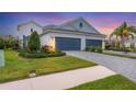 Exterior view showcasing a three-car garage, manicured lawn, and beautiful landscaping at 12810 Seasong Ter, Bradenton, FL 34211