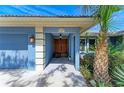 Inviting front entrance with a beautiful wooden double door and well-maintained landscaping at 2299 Riverwood Ct, Sarasota, FL 34231