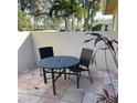 Cozy patio features a round dining table and chairs with tropical landscaping, perfect for relaxing outdoors at 7030 W Country Club N Dr # 128, Sarasota, FL 34243