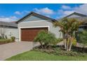 Beautiful home with a large garage, lush lawn, and lovely landscaping including a palm tree at 12525 Lily Quartz Loop, Parrish, FL 34219