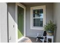 Inviting front porch with a green door, white trim, and a chair perfect for enjoying the outdoors at 12525 Lily Quartz Loop, Parrish, FL 34219