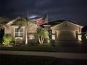 Beautiful exterior of home with paver driveway, 2 car garage, manicured lawn, and a flagpole showing the American flag at 20296 Bandera Pl, Venice, FL 34293