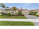 Charming single-story home featuring a well-manicured lawn, beautiful landscaping, and a neutral color palette at 20296 Bandera Pl, Venice, FL 34293