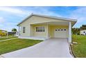 Home featuring a covered carport and garage with a driveway and well maintained lawn at 4531 13Th E St, Ellenton, FL 34222