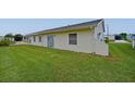 Rear view of the home, siding, and large green lawn at 4531 13Th E St, Ellenton, FL 34222
