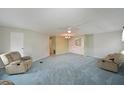 Spacious living room features plush carpeting, a ceiling fan, and built in shelving at 4531 13Th E St, Ellenton, FL 34222