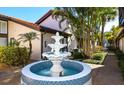 Charming community water feature with blue mosaic tile, tropical landscaping, and swaying palm trees at 800 S Blvd Of Presidents # 12, Sarasota, FL 34236