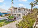 Beautiful two-story home with lush landscaping and a charming wraparound balcony at 203 72Nd St, Holmes Beach, FL 34217