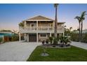 Charming home with a two-car garage, a well-manicured lawn, and a lush tropical landscape at 203 72Nd St, Holmes Beach, FL 34217
