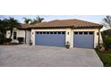 Charming home showcasing a two-car garage with striking blue doors and a spacious concrete driveway at 3001 Seasons Blvd, Sarasota, FL 34240