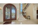 Grand foyer featuring a wrought iron staircase and ornate double doors at 3625 Casey Key Rd, Nokomis, FL 34275