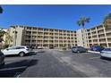 Spacious condo building featuring multiple balconies, palm trees, and ample parking at 3682 Lake Bayshore Dr # K402, Bradenton, FL 34205