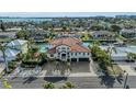 Aerial view of waterfront home showing red tile roof, lush landscaping, pool, and canal access at 550 Yardarm Ln, Longboat Key, FL 34228