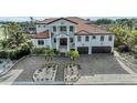 Luxurious two-story home boasts a red tile roof, prominent pillars, and a spacious brick driveway at 550 Yardarm Ln, Longboat Key, FL 34228
