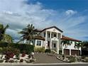 Stately two-story home features a red tile roof, prominent pillars, and a circular brick driveway at 550 Yardarm Ln, Longboat Key, FL 34228