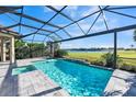 Inviting screened-in pool with a lake view, hot tub, and brick patio, perfect for relaxation at 12826 Sorrento Way, Bradenton, FL 34211