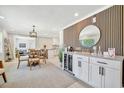 A modern open concept floor plan with bar, dining space and wood look accent wall and light neutral finishes at 3902 11Th W Ave, Bradenton, FL 34205