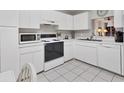 Bright kitchen with white cabinets, modern appliances, and tile flooring for a clean, contemporary aesthetic at 542 Lakeside Dr # 542, Bradenton, FL 34210