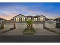 Stunning townhome features a private garage and beautiful Mediterranean-style architecture at sunset at 6065 Worsham Ln # 104, Bradenton, FL 34211