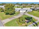 Single-story home boasting lush green lawns, a beautiful landscape design, and an attached single-car garage at 7304 11Th W Ave, Bradenton, FL 34209
