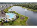 Aerial view of the community pool and splash fountain overlooking the community lake at 13891 Heartwood Way, Parrish, FL 34219