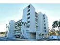 Modern condo building boasts multiple balconies with stunning views, enhanced by swaying palm trees at 240 Sands Point Rd # 4201, Longboat Key, FL 34228