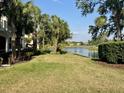 Serene backyard with lush green grass, beautiful lake views, and mature palm trees at 9606 Sea Turtle Ter # 101, Bradenton, FL 34212
