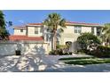 Beautiful two-story home featuring a two-car garage, a red tile roof and lush tropical landscaping at 9606 Sea Turtle Ter # 101, Bradenton, FL 34212